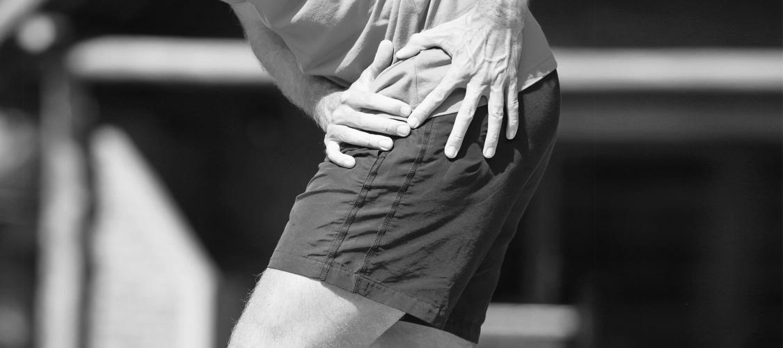 Man clutching at painful hip. 
